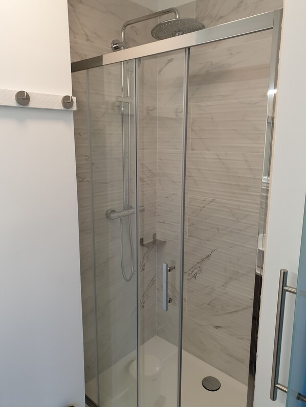 A glass-enclosed shower with a handheld showerhead and a wall-mounted faucet. - B&B Luxe Suites 1-2-3 (Antwerp)