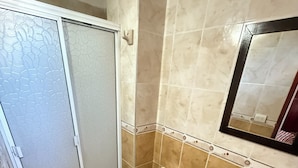 A bathroom with a toilet, sink, and mirror. - Hotel La Casa del Turista (Cartagena)