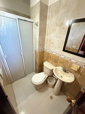 Une salle de bain avec des toilettes, un lavabo et un miroir.