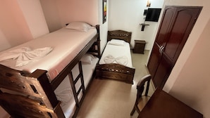 A narrow room with two bunk beds, a wooden desk, a chair, a small table, and a wardrobe. - Hotel La Casa del Turista (Cartagena)