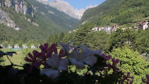 A mountainous landscape with residential buildings nestled among the hills. - Garnì Lago Alpino (Molveno)