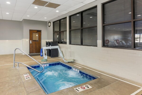 A pool area with a diving board, a clock on the wall, and a window with blinds. - Best Western Plus Williston Hotel & Suites (Williston)