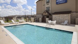 A swimming pool with lounge chairs and a sign for 'MICROTEL INN & SUITES BY WYNDHAM'. - Microtel Inn & Suites Odessa TX (Odessa)