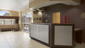 A reception area with a counter, chairs, and a view of the outside. - Microtel Inn & Suites Odessa TX (Odessa)