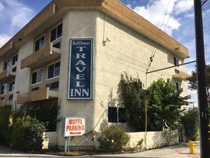 A building with a sign for Bellflower Travel Inn and a motel parking sign. - Bellflower Travel Inn (Bellflower)