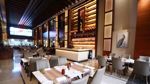 Un restaurant doté de plusieurs tables, de chaises et d’un bar.