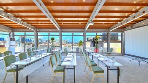 A conference room with tables, chairs, and large windows offering a city view. - Ramada by Wyndham Istanbul Taksim (Istanbul)