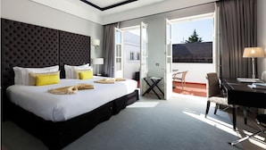 A hotel room with a large bed, a desk, and a balcony with a view. - Alentejo Marmoris Hotel & Spa, (Vila Vicosa)