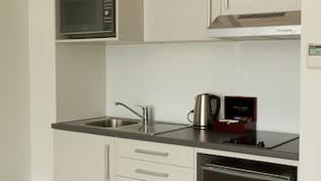 Cuina compacta amb microones, rentapelats, cafetera i rentavaixelles integrat.