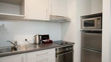 A modern kitchen with stainless steel appliances, white cabinetry, and a built-in microwave.