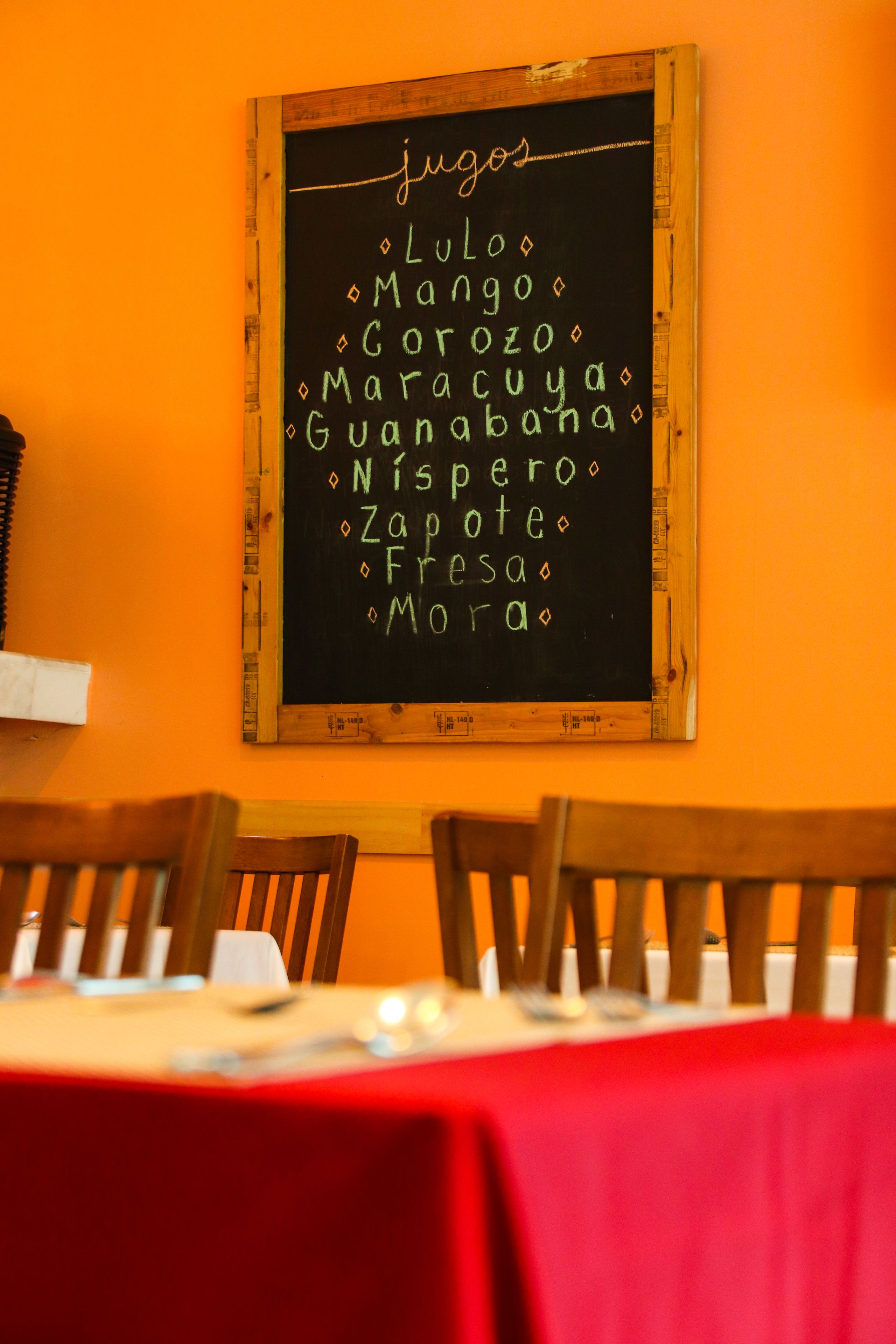 A restaurant interior with a chalkboard menu listing various dishes.