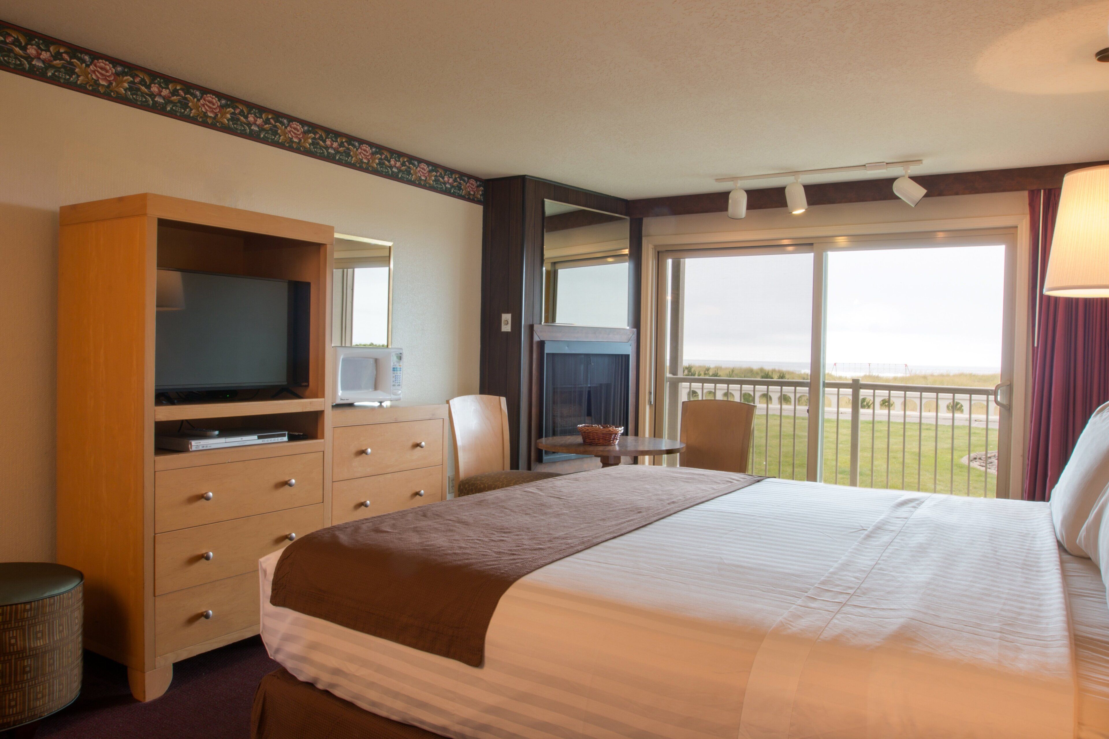 Une chambre d’hôtel avec un grand lit, une télévision, un bureau et un balcon avec vue.