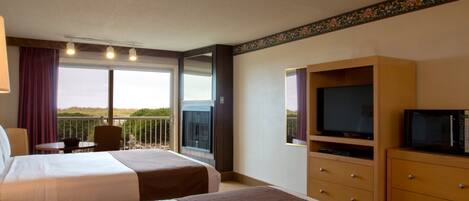 Une chambre d’hôtel avec deux lits, une télévision, une commode et un balcon avec vue.