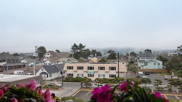 A building with a sign reading "Hi-Tide" in a residential area with houses, a parking lot, and flowering plants in the foreground.