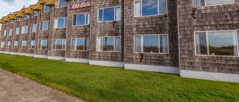 Un hotel de varios pisos con fachada uniforme, que presenta una fila de ventanas y un letrero que dice "EbbTide".