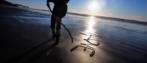 Silueta de una persona en la playa al atardecer.