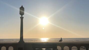 Un banco y un farol junto al mar al atardecer.