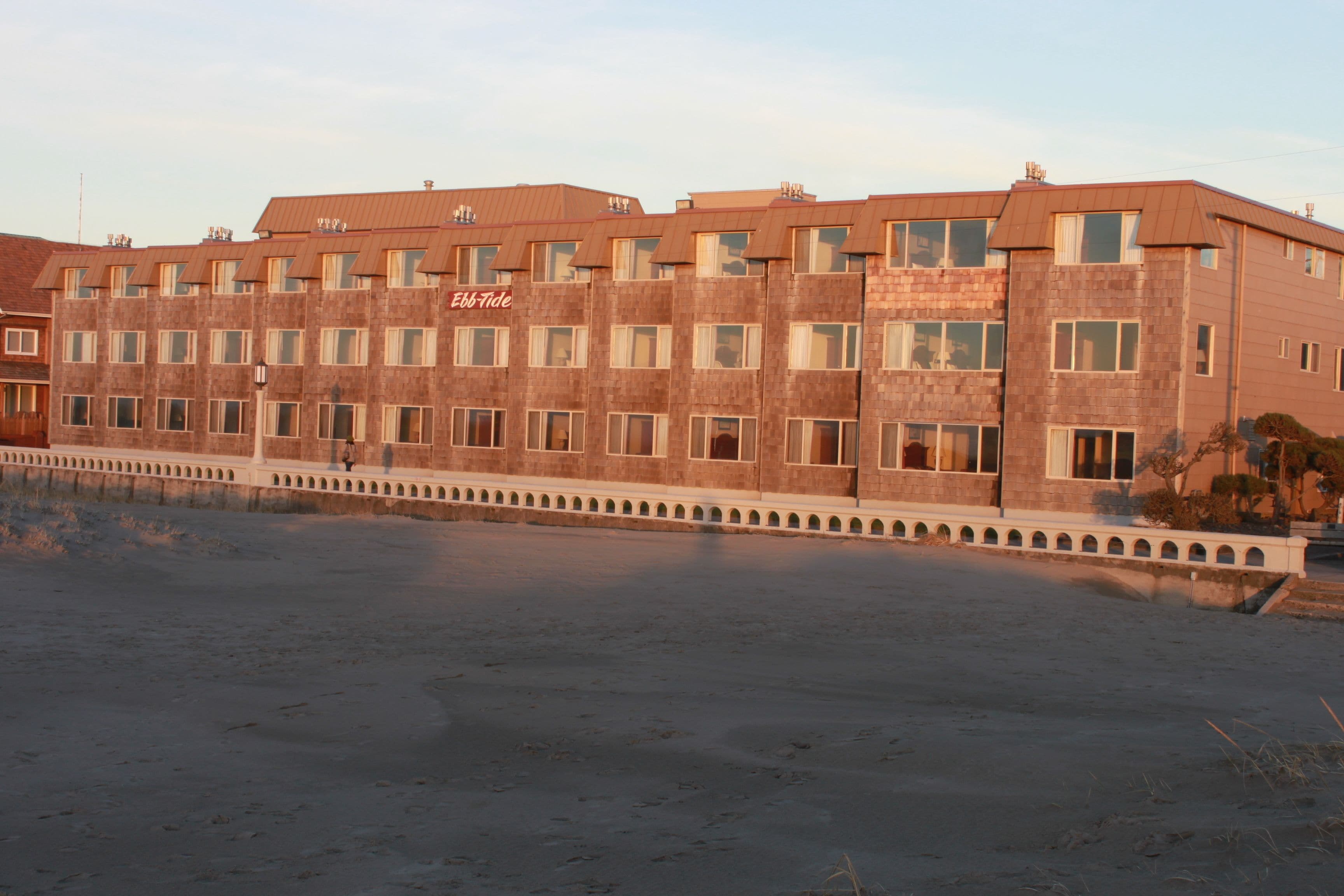 Un hotel de varios pisos con fachada de ladrillo y una fila de ventanas en cada planta.