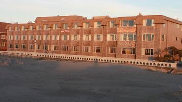 Un hotel de varios pisos con fachada de ladrillo y una fila de ventanas en cada planta.