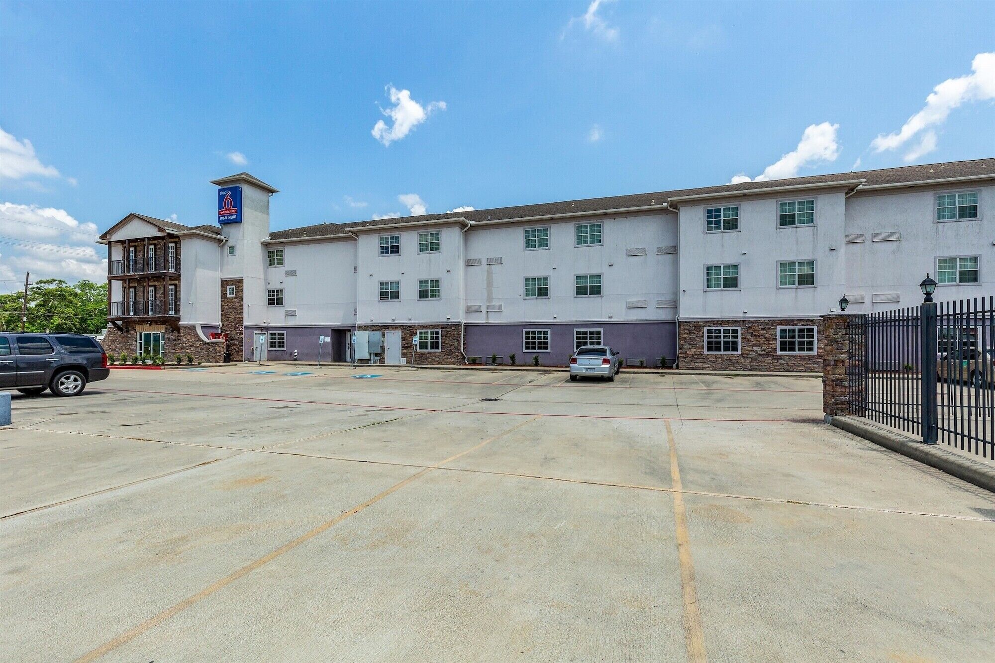 A multi-story building with a parking lot in front.