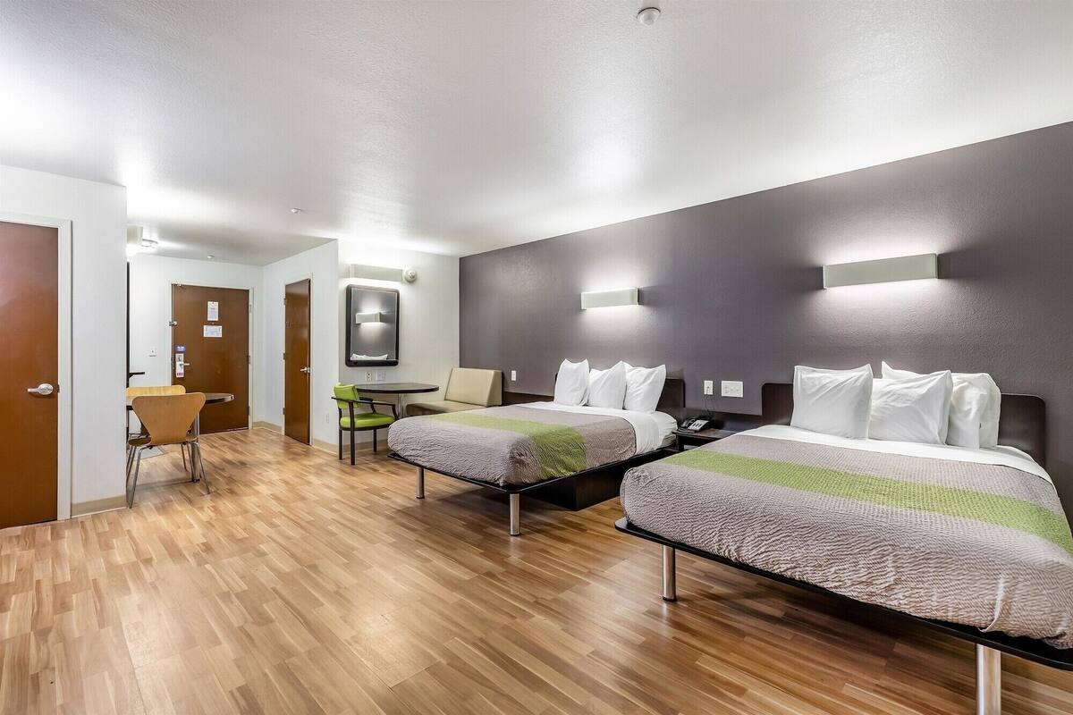 Ett hotellrum med två sängar, ett litet bord och en stol.