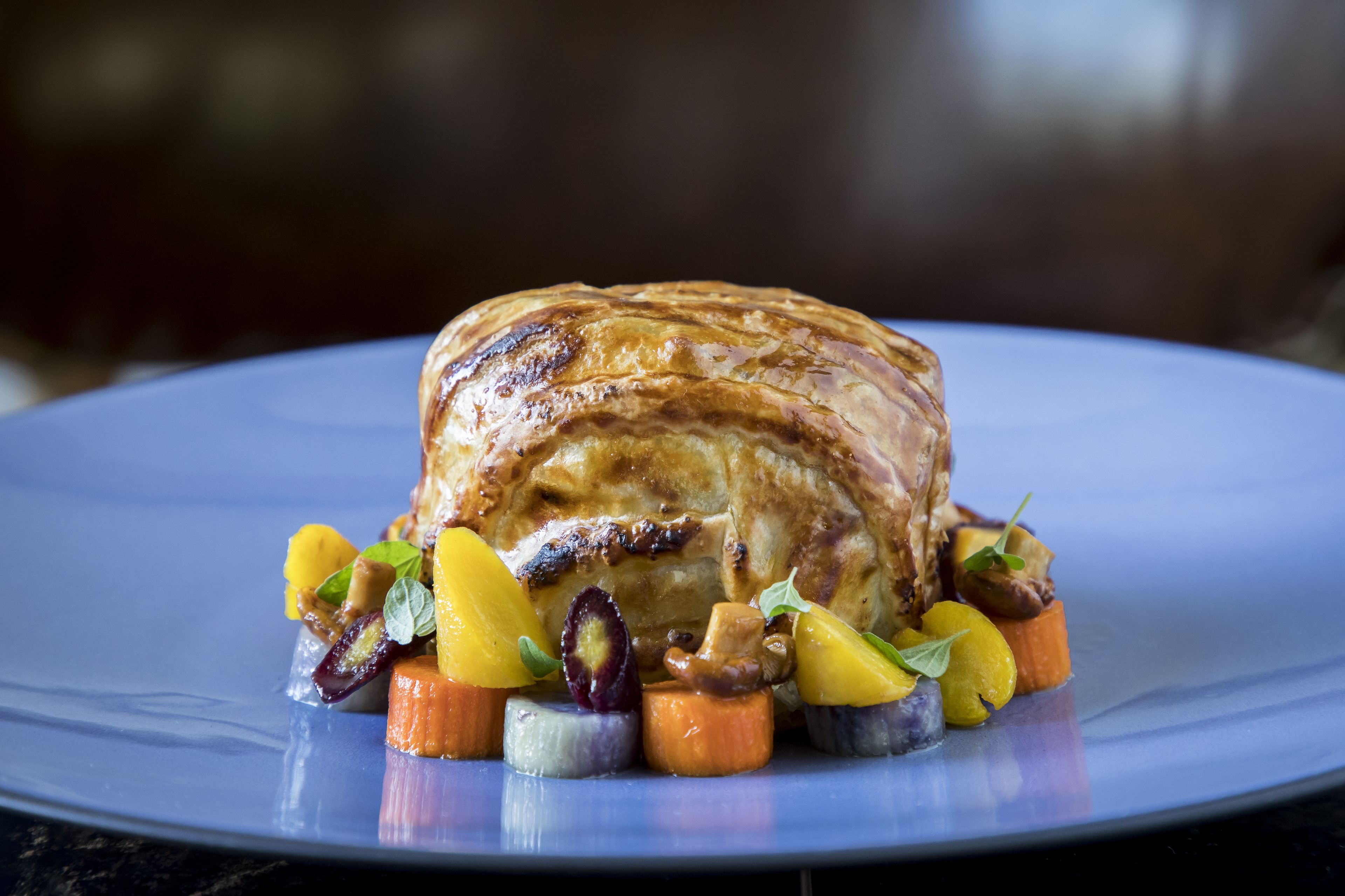 A roasted meat dish with vegetables on a plate.