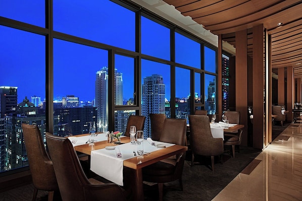 A high-rise restaurant with a city view, modern decor, and a spacious layout. - Millennium Hotel Taichung (Taichung)