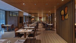 A modern restaurant with long tables, chairs, and a wooden ceiling. - Millennium Hotel Taichung (Taichung)