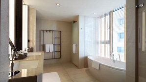Un baño moderno con dos lavamanos, una bañera y una ducha.