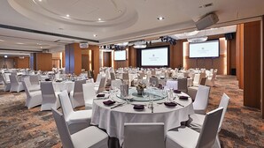A conference room with round tables, white chairs, and a carpeted floor. - Millennium Hotel Taichung (Taichung)