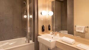 A modern bathroom with a bathtub, a sink, and a large mirror. - ibis Douai Dechy (Dechy)