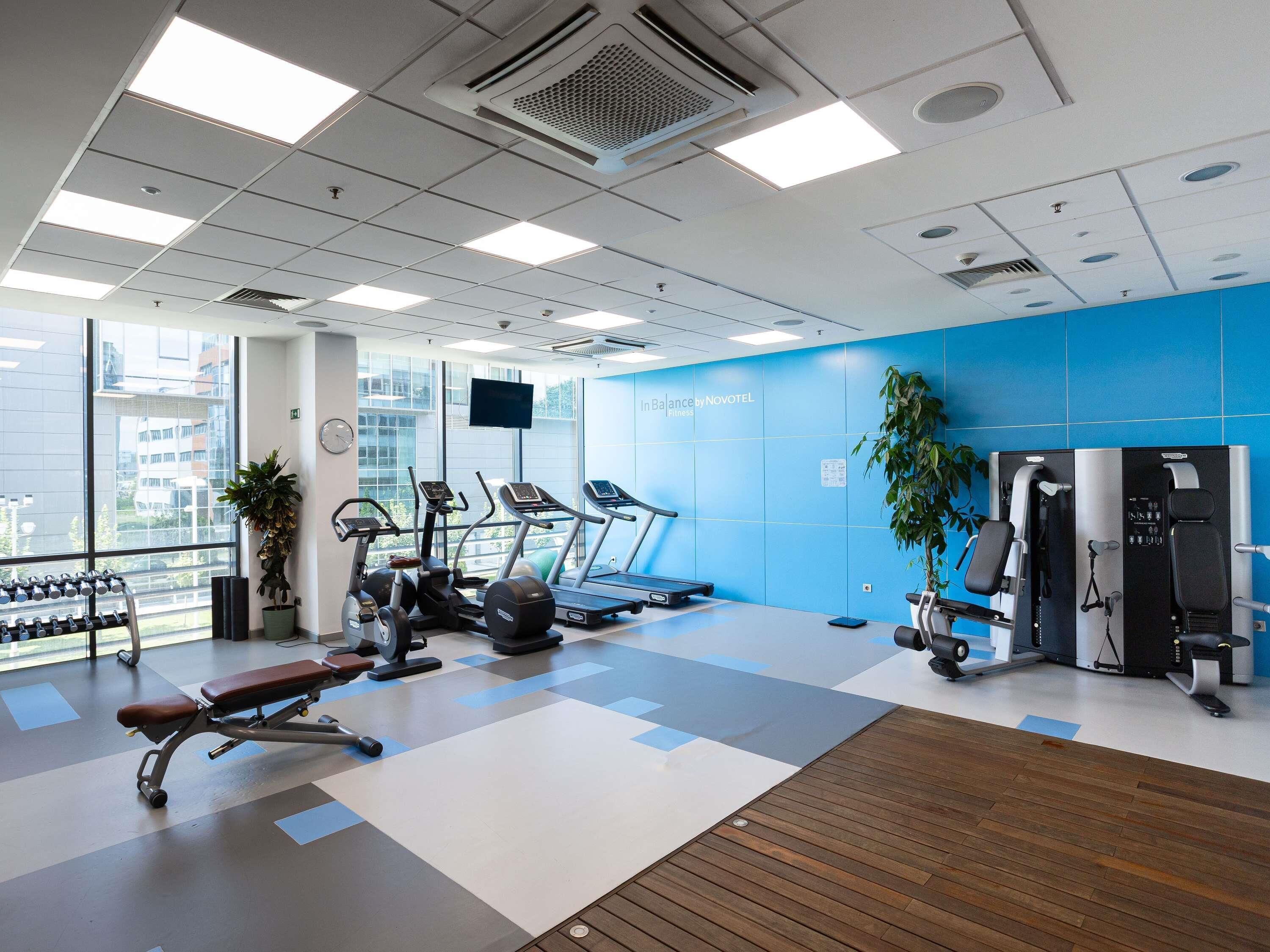 Une salle de sport équipée de tapis de course, de vélos elliptiques et de matériel de musculation.