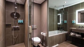 A modern bathroom with a glass-enclosed shower, a toilet, a bathtub, and a vanity with a mirror.