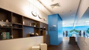 Un interior moderno con suelo de madera, unidades de almacenaje blancas y una pared azul de acento.