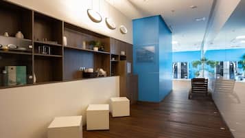 A modern interior with wooden flooring, white storage units, and a blue accent wall.