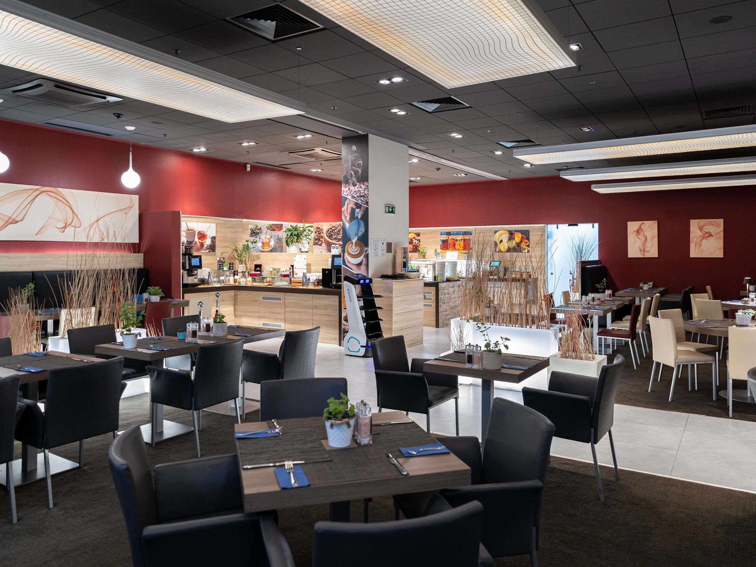 Un interior de restaurante moderno con mesas, sillas y una zona de barra.