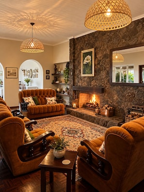 A cozy living room with a fireplace, comfortable seating, and decorative elements. - Musketeers Lodge (Bulawayo)