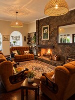 A cozy living room with a fireplace, comfortable seating, and decorative elements.