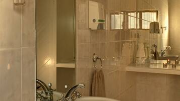 A bathroom with a white sink, mirror, and tiled walls.