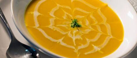A bowl of soup with a decorative swirl pattern on the surface.