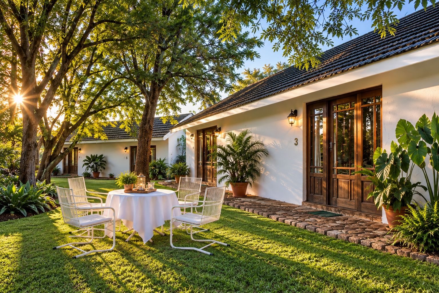 Una casa con patio, mobiliario exterior y plantas en macetas.