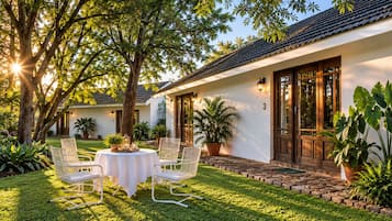 A house with a patio, outdoor seating, and potted plants.