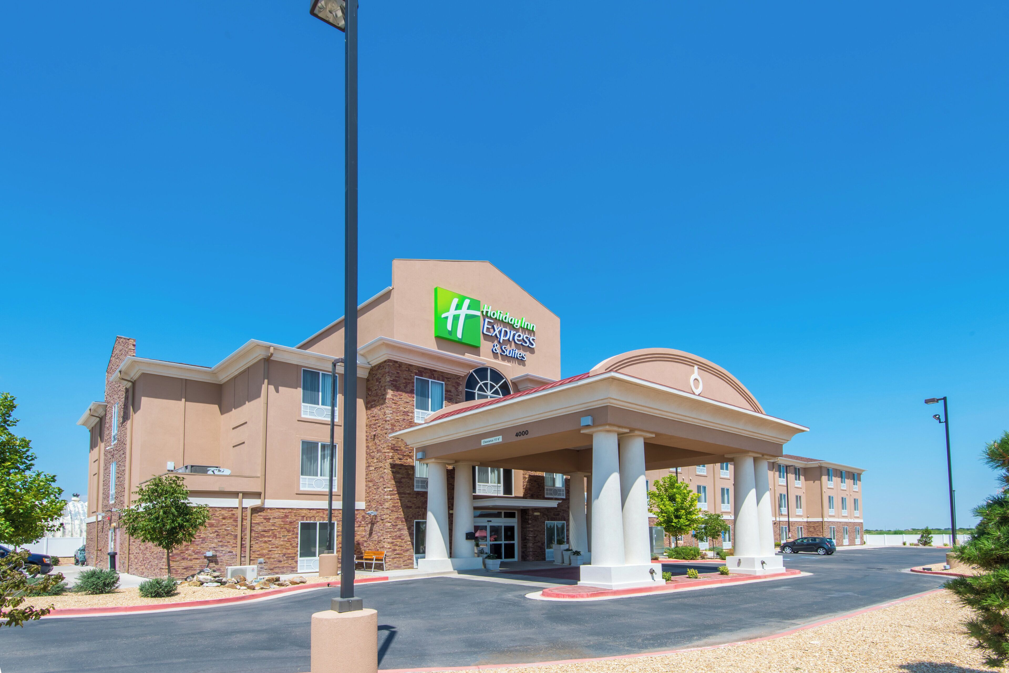 A Holiday Inn Express & Suites hotel with a covered entrance and a parking lot.