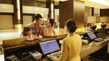 Et hotelreceptionsområde med indcheckningsdisk, computere og en telefon.