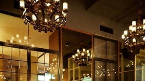 Una pareja cenando en un restaurante con amplias ventanas y candelabros.