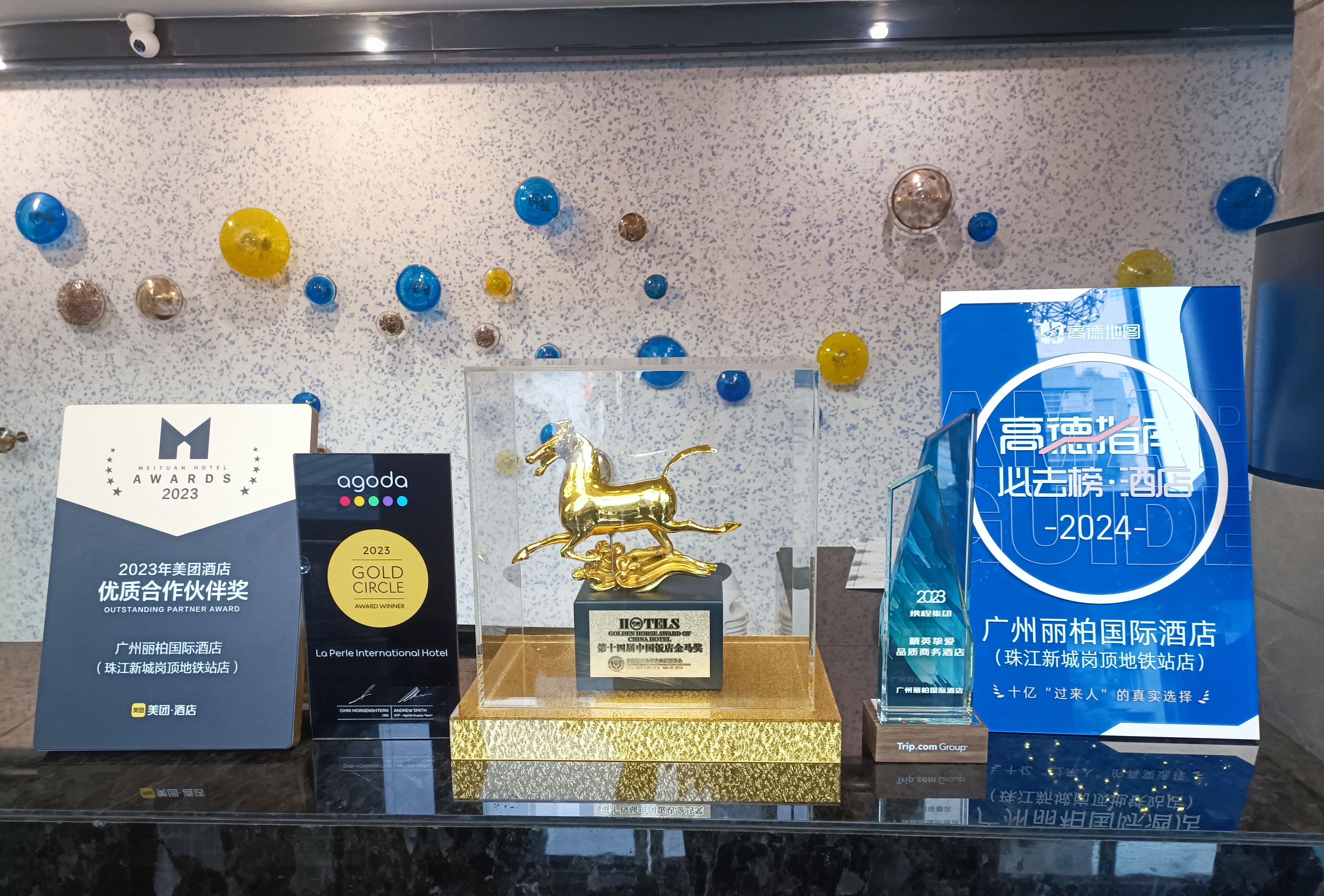 Awards and a gold horse statue displayed on a counter.