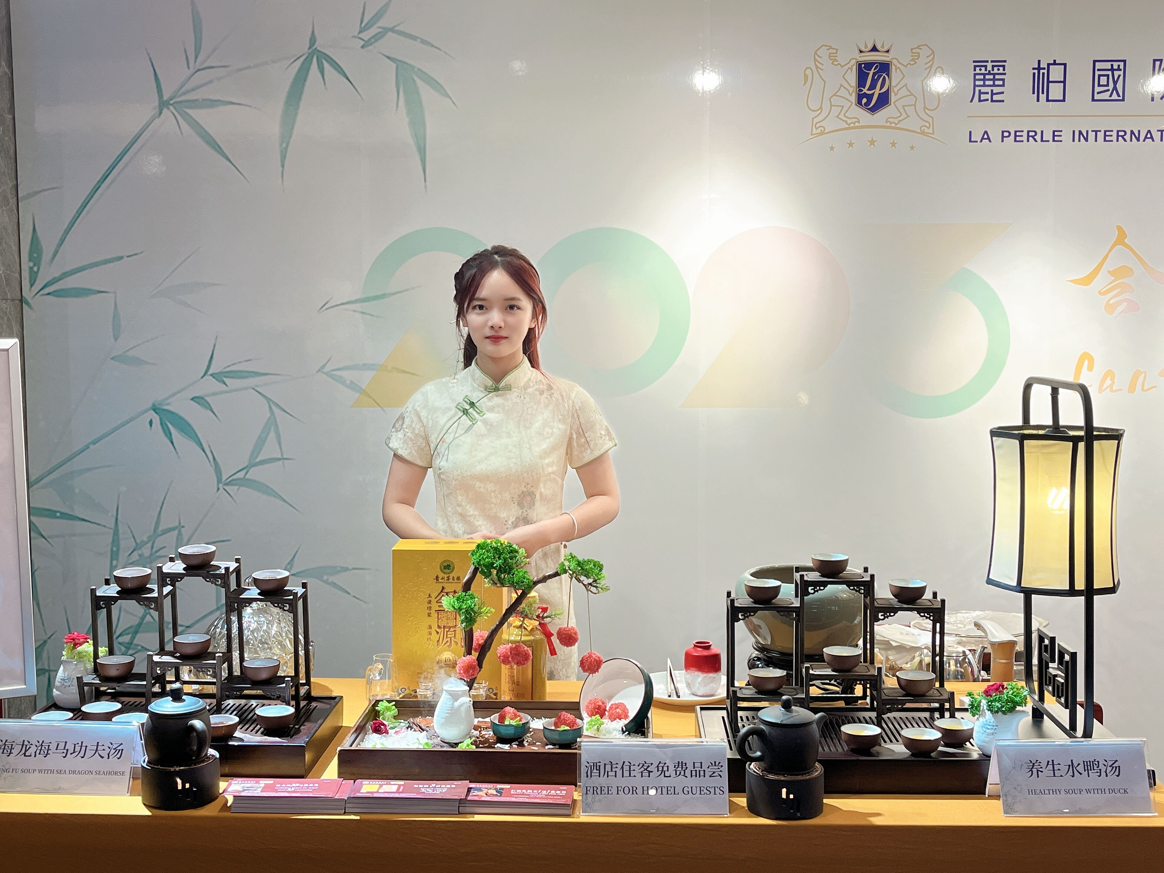 A hotel display with tea sets, a teapot, and a sign offering free soup to guests.