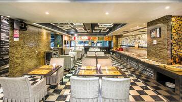 A restaurant with checkered flooring, tables with chairs, and a counter with food items.