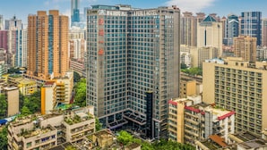 Un hotel de gran altura con varios pisos, amplias ventanas y un letrero llamativo.