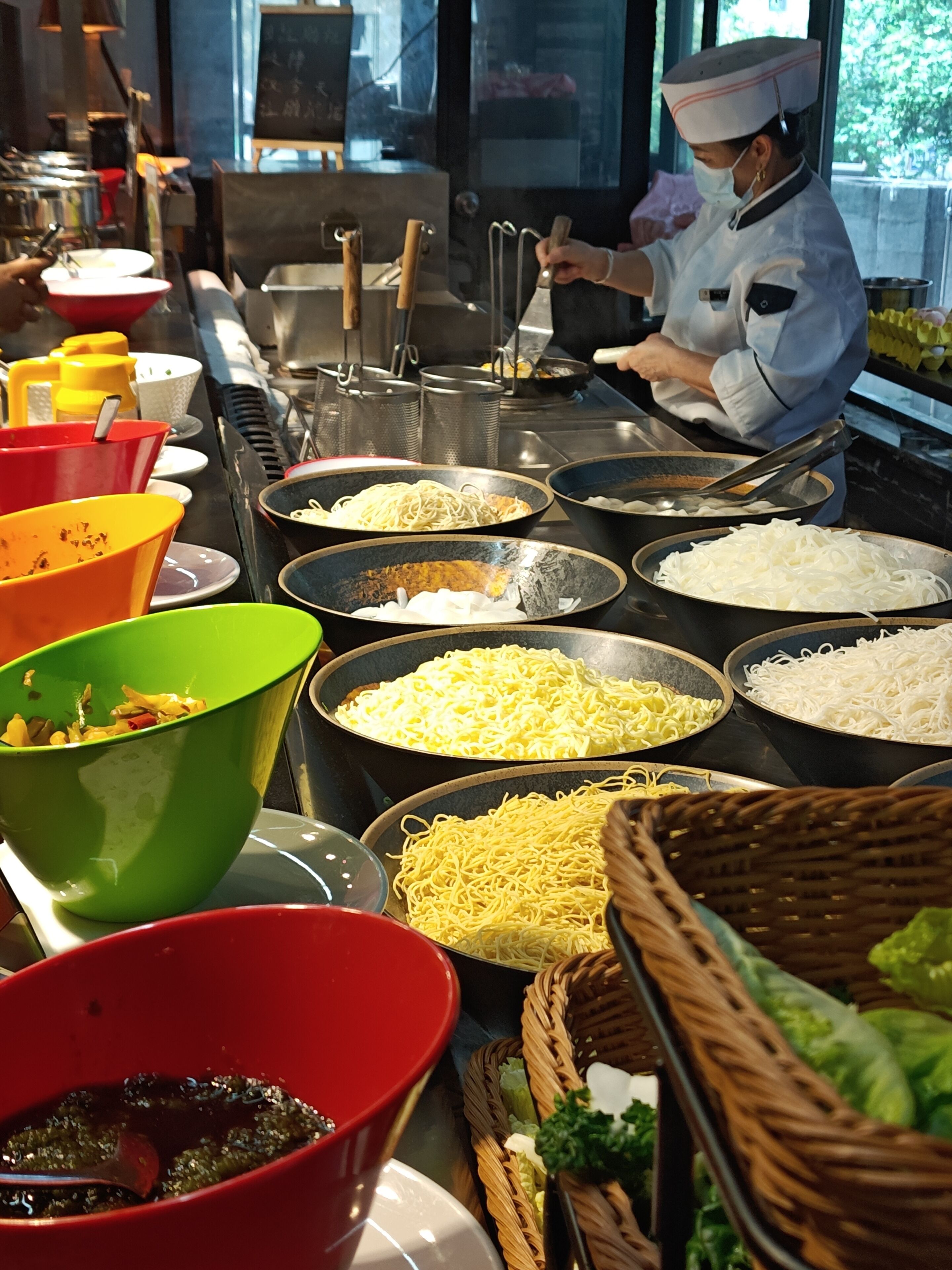 A buffet setup with various dishes and utensils.